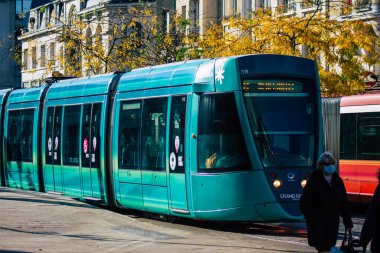 Fransa 'yı 31 Ekim 2020' de, Fransa 'nın Grand Est bölgesindeki bir şehir olan Reims toplu taşıma sisteminin bir parçası olan caddelerden geçen yolcular için modern bir elektrikli tramvaya bakıyor.