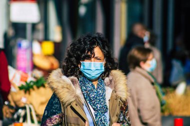 Fransa 'yı 14 Kasım 2020' de Coronavirus salgını sırasında ve nüfusu kontrol altına almak için çarşıda maske alışverişi yapan kimliği belirsiz kişilerin portresi olarak gösteriyor.