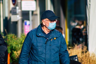 Fransa 'yı 14 Kasım 2020' de Coronavirus salgını sırasında ve nüfusu kontrol altına almak için çarşıda maske alışverişi yapan kimliği belirsiz kişilerin portresi olarak gösteriyor.