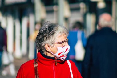 Fransa 'yı 14 Kasım 2020' de Coronavirus salgını sırasında ve nüfusu kontrol altına almak için çarşıda maske alışverişi yapan kimliği belirsiz kişilerin portresi olarak gösteriyor.