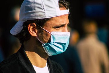 Fransa 'yı 14 Kasım 2020' de Coronavirus salgını sırasında ve nüfusu kontrol altına almak için çarşıda maske alışverişi yapan kimliği belirsiz kişilerin portresi olarak gösteriyor.