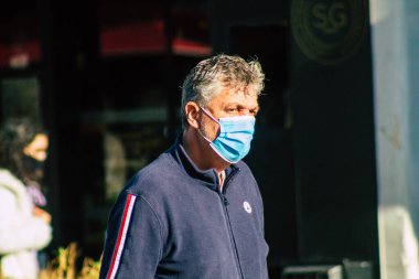 Fransa 'yı 14 Kasım 2020' de Coronavirus salgını sırasında ve nüfusu kontrol altına almak için çarşıda maske alışverişi yapan kimliği belirsiz kişilerin portresi olarak gösteriyor.