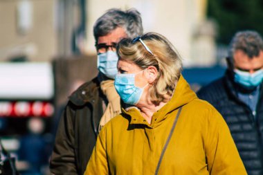Fransa 'yı 14 Kasım 2020' de Coronavirus salgını sırasında ve nüfusu kontrol altına almak için çarşıda maske alışverişi yapan kimliği belirsiz kişilerin portresi olarak gösteriyor.
