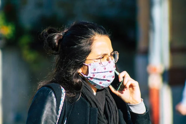 Fransa 'yı 14 Kasım 2020' de Coronavirus salgını sırasında ve nüfusu kontrol altına almak için çarşıda maske alışverişi yapan kimliği belirsiz kişilerin portresi olarak gösteriyor.