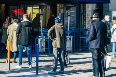 Fransa 14 Kasım 2020 'de Coronavirus salgını sırasında şehir merkezindeki markette kuyruğa giren ve nüfusu kontrol altına almak için bekleyen kimliği belirsiz insanların görüntüsü.