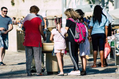 Kudüs İsrail 2 Temmuz 2019, öğleden sonra Kudüs 'ün batı duvarındaki fıskiyeye içen bilinmeyen İsrailli insanların görüntüsü.