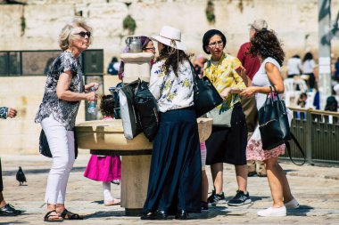 Kudüs İsrail 2 Temmuz 2019, öğleden sonra Kudüs 'ün batı duvarındaki fıskiyeye içen bilinmeyen İsrailli insanların görüntüsü.