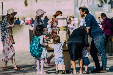 Kudüs İsrail 2 Temmuz 2019, öğleden sonra Kudüs 'ün batı duvarındaki fıskiyeye içen bilinmeyen İsrailli insanların görüntüsü.