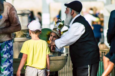 Kudüs İsrail 2 Temmuz 2019, öğleden sonra Kudüs 'ün batı duvarındaki fıskiyeye içen bilinmeyen İsrailli insanların görüntüsü.