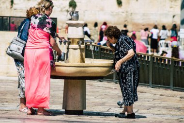 Kudüs İsrail 2 Temmuz 2019, öğleden sonra Kudüs 'ün batı duvarındaki fıskiyeye içen bilinmeyen İsrailli insanların görüntüsü.