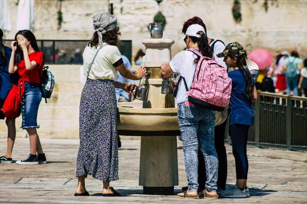 Kudüs İsrail 2 Temmuz 2019, öğleden sonra Kudüs 'ün batı duvarındaki fıskiyeye içen bilinmeyen İsrailli insanların görüntüsü.