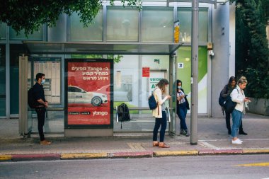 Tel Aviv İsrail 23 Aralık 2020 'de İsrail' deki Coronavirus salgını sırasında otobüs durağında bekleyen yüzü maskeli kimliği belirsiz bir İsrailli 'nin görüntüsü.