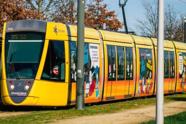 26 Aralık 2020 'de Fransa' yı sokaklardan geçen ve Fransa 'daki Reims toplu taşıma sisteminin bir parçası olan yolculara yönelik modern bir elektrikli tramvaya bakıyor.