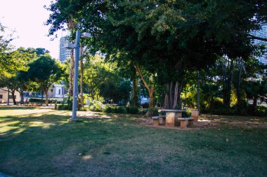 Tel Aviv İsrail 28 Aralık 2020 Sarona Mahallesi, eski bir yerleşim yeri, bir Alman Protestan topluluğu ve Ganei Sarona, gökdelenlerin arka planına karşı korunmuş evleri olan bir park