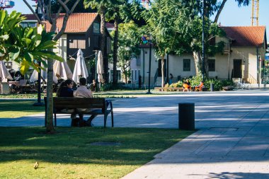 Tel Aviv İsrail 28 Aralık 2020 Sarona Mahallesi, eski bir yerleşim yeri, bir Alman Protestan topluluğu ve Ganei Sarona, gökdelenlerin arka planına karşı korunmuş evleri olan bir park