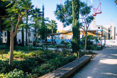 Tel Aviv İsrail 28 Aralık 2020 Sarona Mahallesi, eski bir yerleşim yeri, bir Alman Protestan topluluğu ve Ganei Sarona, gökdelenlerin arka planına karşı korunmuş evleri olan bir park