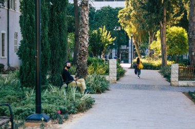 Tel Aviv İsrail 28 Aralık 2020 Sarona Mahallesi, eski bir yerleşim yeri, bir Alman Protestan topluluğu ve Ganei Sarona, gökdelenlerin arka planına karşı korunmuş evleri olan bir park