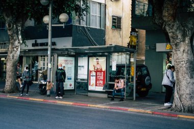 Tel Aviv İsrail 13 Ocak 2021 'de İsrail' deki Coronavirus salgını sırasında otobüs durağında bekleyen yüzü maskeli kimliği belirsiz bir İsrailli 'nin görüntüsü.