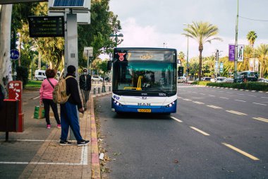 Tel Aviv İsrail 17 Ocak 2021 'de İsrail' deki Coronavirus salgını sırasında otobüs durağında bekleyen yüzü maskeli kimliği belirsiz bir İsrailli 'nin görüntüsü.