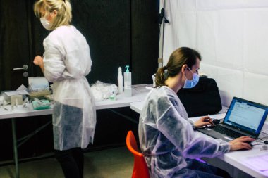 Reims şehrindeki bir aşı merkezinde 18 Ocak 2021 'de Fransa' yı ziyaret eden insanlar, virüsün yayılmasını sınırlamak için Fransız vatandaşlarının Coronavirus aşısını almalarına hoş geldiniz diyor.