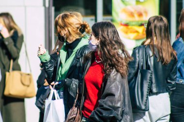 Fransa 'yı 16 Şubat 2021' de Reims sokaklarında yürüyen ve Fransa 'yı etkileyen salgın sırasında kendilerini koronavirüsten korumak için maske takan kimliği belirsiz bir yaya.