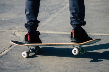 Reims Fransa 'da 26 Şubat 2021' de Fransa 'yı etkileyen salgın sırasında Reims caddesinde kaykay yapan kimliği belirsiz gençler görülüyor.