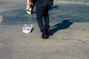 Reims Fransa 'da 26 Şubat 2021' de Fransa 'yı etkileyen salgın sırasında Reims caddesinde kaykay yapan kimliği belirsiz gençler görülüyor.