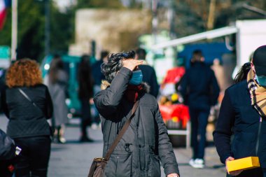 Reims 'de 27 Şubat 2021' de Fransa 'yı etkileyen salgın sırasında Reims sokaklarında yürüyen koronavirüsten kendilerini korumak için maske takan kimliği belirsiz yayalar görülüyor.