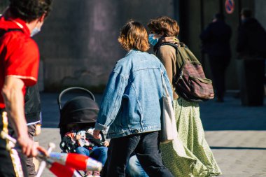 Reims 'de 27 Şubat 2021' de Fransa 'yı etkileyen salgın sırasında Reims sokaklarında yürüyen koronavirüsten kendilerini korumak için maske takan kimliği belirsiz yayalar görülüyor.