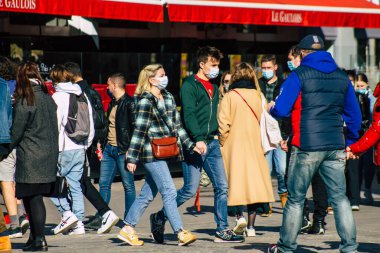 Reims 'de 27 Şubat 2021' de Fransa 'yı etkileyen salgın sırasında Reims sokaklarında yürüyen koronavirüsten kendilerini korumak için maske takan kimliği belirsiz yayalar görülüyor.
