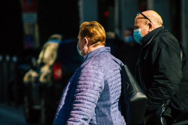 Reims 'de 27 Şubat 2021' de Fransa 'yı etkileyen salgın sırasında Reims sokaklarında yürüyen koronavirüsten kendilerini korumak için maske takan kimliği belirsiz yayalar görülüyor.