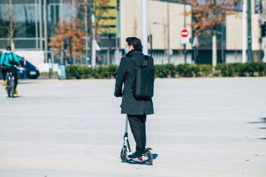 Reims caddelerinde elektrikli scooterla gezen 3 Mart 2021 'de küçük bir iç yanmalı motorlar ve merkezde bir güverte ile çalışan insanlar var.