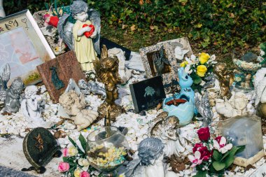 Fransa 'yı 3 Mart 2021' de Coronavirus salgını sırasında Fransa 'yı vuran Reims şehrinin mezarlıklarında bulunan anılara yerleştirilen dini objeler olarak tanımlıyor.