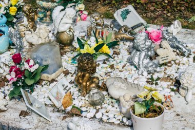 Fransa 'yı 3 Mart 2021' de Coronavirus salgını sırasında Fransa 'yı vuran Reims şehrinin mezarlıklarında bulunan anılara yerleştirilen dini objeler olarak tanımlıyor.