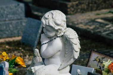 Fransa 'yı 3 Mart 2021' de Coronavirus salgını sırasında Fransa 'yı vuran Reims şehrinin mezarlıklarında bulunan anılara yerleştirilen dini objeler olarak tanımlıyor.