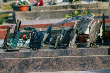 Fransa 'yı 3 Mart 2021' de Coronavirus salgını sırasında Fransa 'yı vuran Reims şehrinin mezarlıklarında bulunan anılara yerleştirilen dini objeler olarak tanımlıyor.