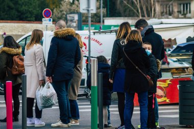 Paris Fransa 20 Mart 2021 'de Paris sokaklarında yürüyen ve nüfusu zapt etmek için koronavirüsten kendini korumak için maske takan bir yayaydı.