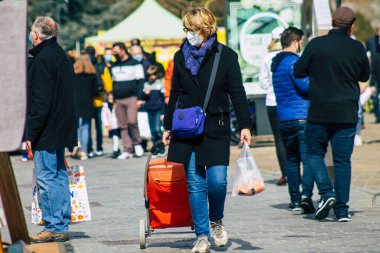 Paris Fransa 20 Mart 2021 'de Paris sokaklarında yürüyen ve nüfusu zapt etmek için koronavirüsten kendini korumak için maske takan bir yayaydı.