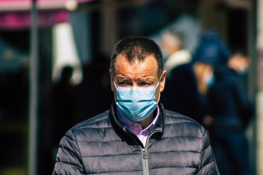 Paris Fransa 20 Mart 2021 'de Paris sokaklarında yürüyen ve nüfusu zapt etmek için koronavirüsten kendini korumak için maske takan bir yayaydı.