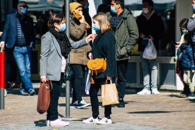 Paris Fransa 20 Mart 2021 'de Paris sokaklarında yürüyen ve nüfusu zapt etmek için koronavirüsten kendini korumak için maske takan bir yayaydı.