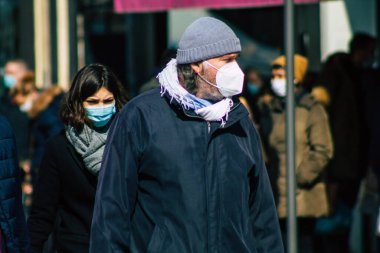 Paris Fransa 20 Mart 2021 'de Paris sokaklarında yürüyen ve nüfusu zapt etmek için koronavirüsten kendini korumak için maske takan bir yayaydı.