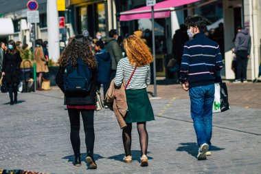 Paris Fransa 20 Mart 2021 'de Paris sokaklarında yürüyen ve nüfusu zapt etmek için koronavirüsten kendini korumak için maske takan bir yayaydı.