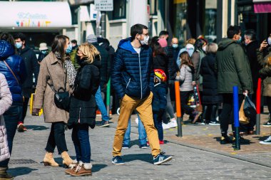 Paris Fransa 20 Mart 2021 'de Paris sokaklarında yürüyen ve nüfusu zapt etmek için koronavirüsten kendini korumak için maske takan bir yayaydı.