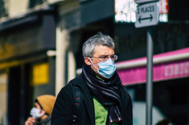 Paris Fransa 20 Mart 2021 'de Paris sokaklarında yürüyen ve nüfusu zapt etmek için koronavirüsten kendini korumak için maske takan bir yayaydı.