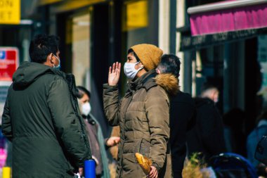 Paris Fransa 20 Mart 2021 'de Paris sokaklarında yürüyen ve nüfusu zapt etmek için koronavirüsten kendini korumak için maske takan bir yayaydı.