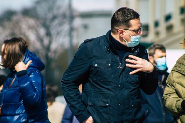 Paris Fransa 20 Mart 2021 'de Paris sokaklarında yürüyen ve nüfusu zapt etmek için koronavirüsten kendini korumak için maske takan bir yayaydı.