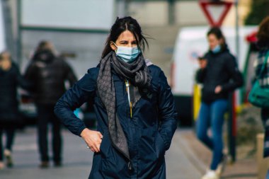 Paris Fransa 20 Mart 2021 'de Paris sokaklarında yürüyen ve nüfusu zapt etmek için koronavirüsten kendini korumak için maske takan bir yayaydı.