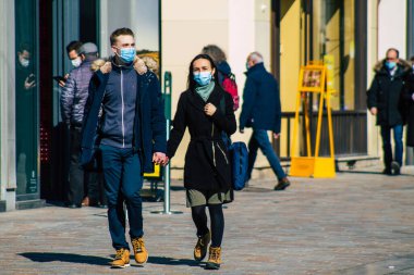Paris Fransa 20 Mart 2021 'de Paris sokaklarında yürüyen ve nüfusu zapt etmek için koronavirüsten kendini korumak için maske takan bir yayaydı.