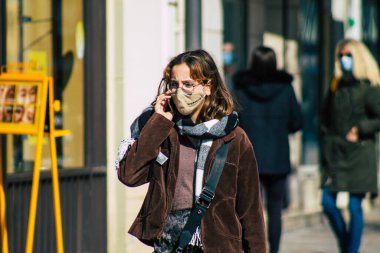 Paris Fransa 20 Mart 2021 'de Paris sokaklarında yürüyen ve nüfusu zapt etmek için koronavirüsten kendini korumak için maske takan bir yayaydı.