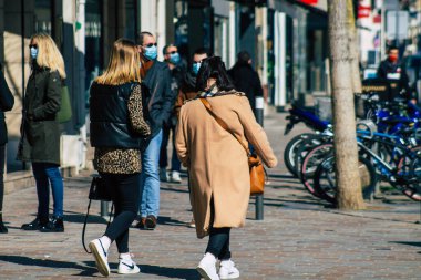 Paris Fransa 20 Mart 2021 'de Paris sokaklarında yürüyen ve nüfusu zapt etmek için koronavirüsten kendini korumak için maske takan bir yayaydı.